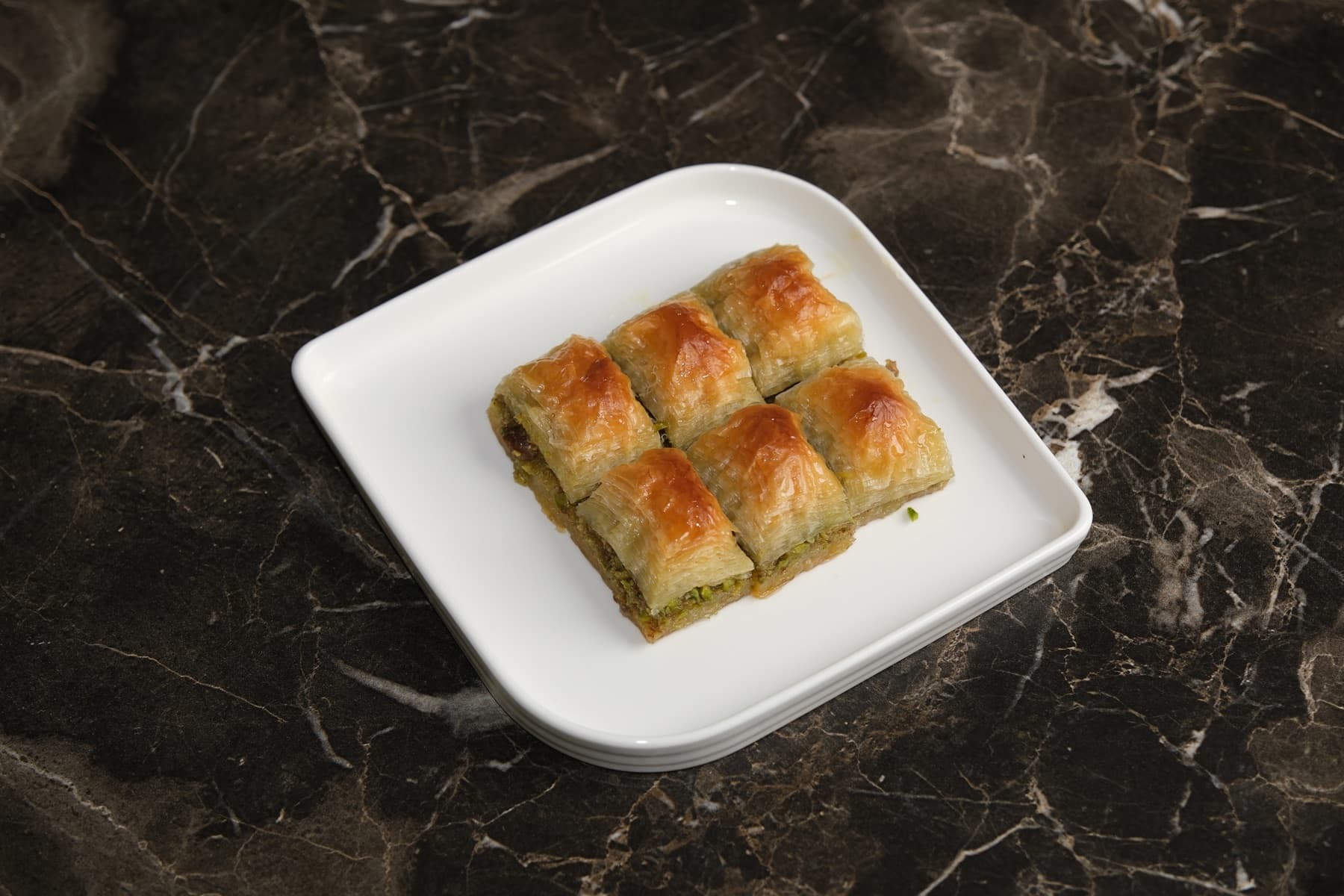 Beyaz tabakta fıstıklı baklava